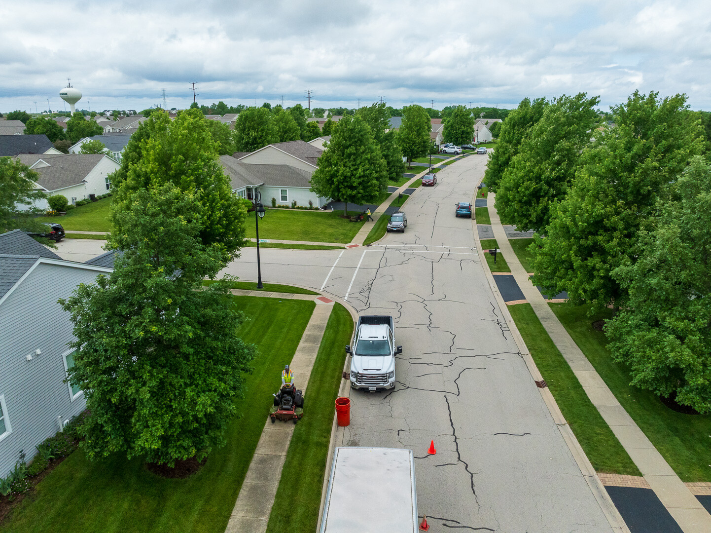 aerial HOA commercial crew trucks parked lawn mowing trees