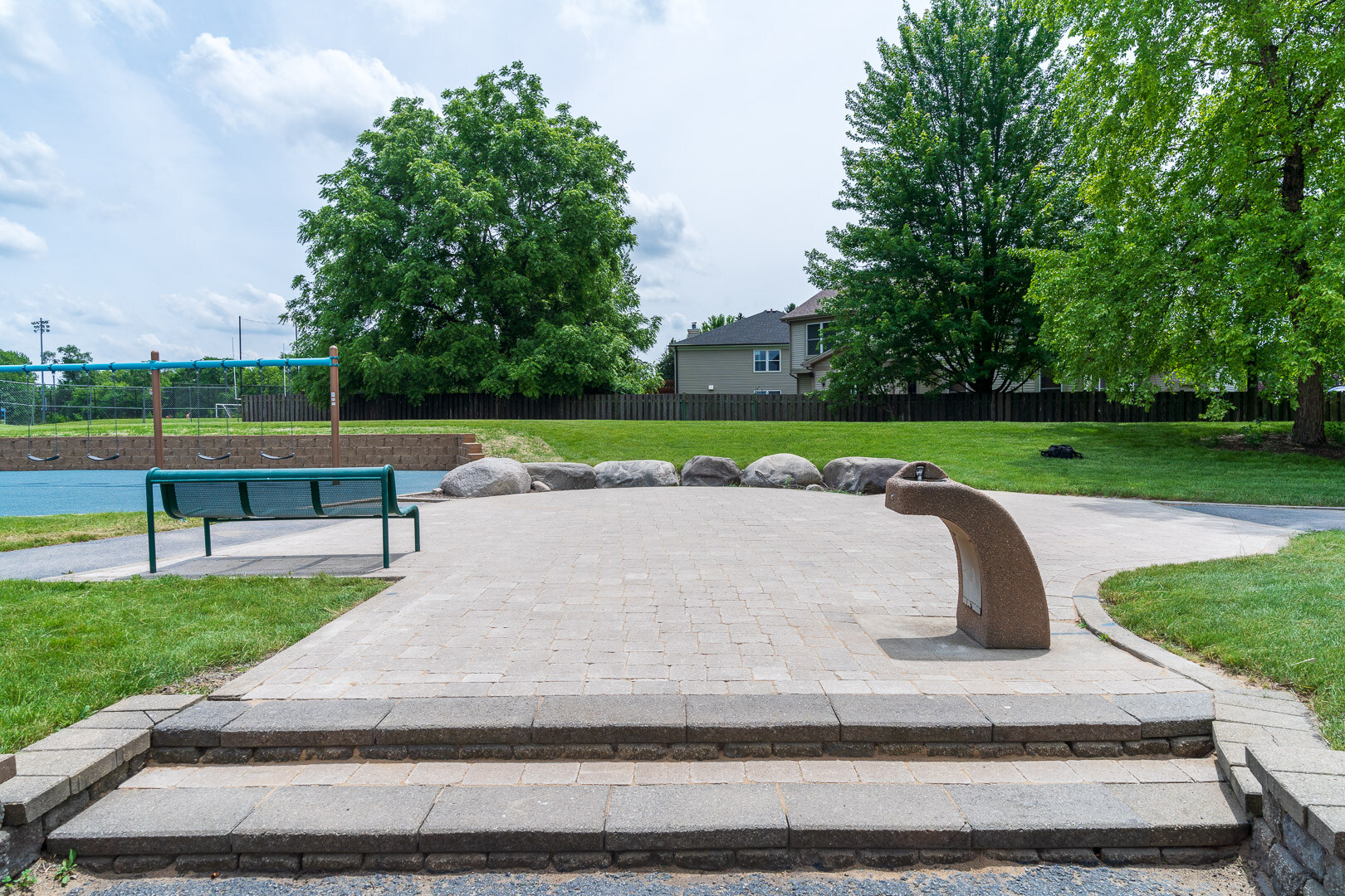 commercial patio and stairs with lawn and shade trees playground