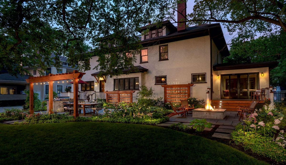 landscape lighting in backyard with pergola and firepit