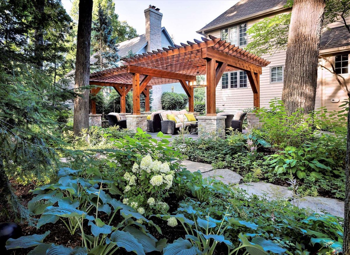 open air pergola with seating and surrounding landscaping