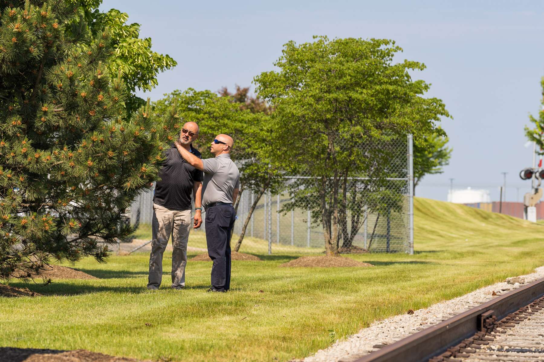 property manager and landscape account manager reviewing trees in an industrial park landscape