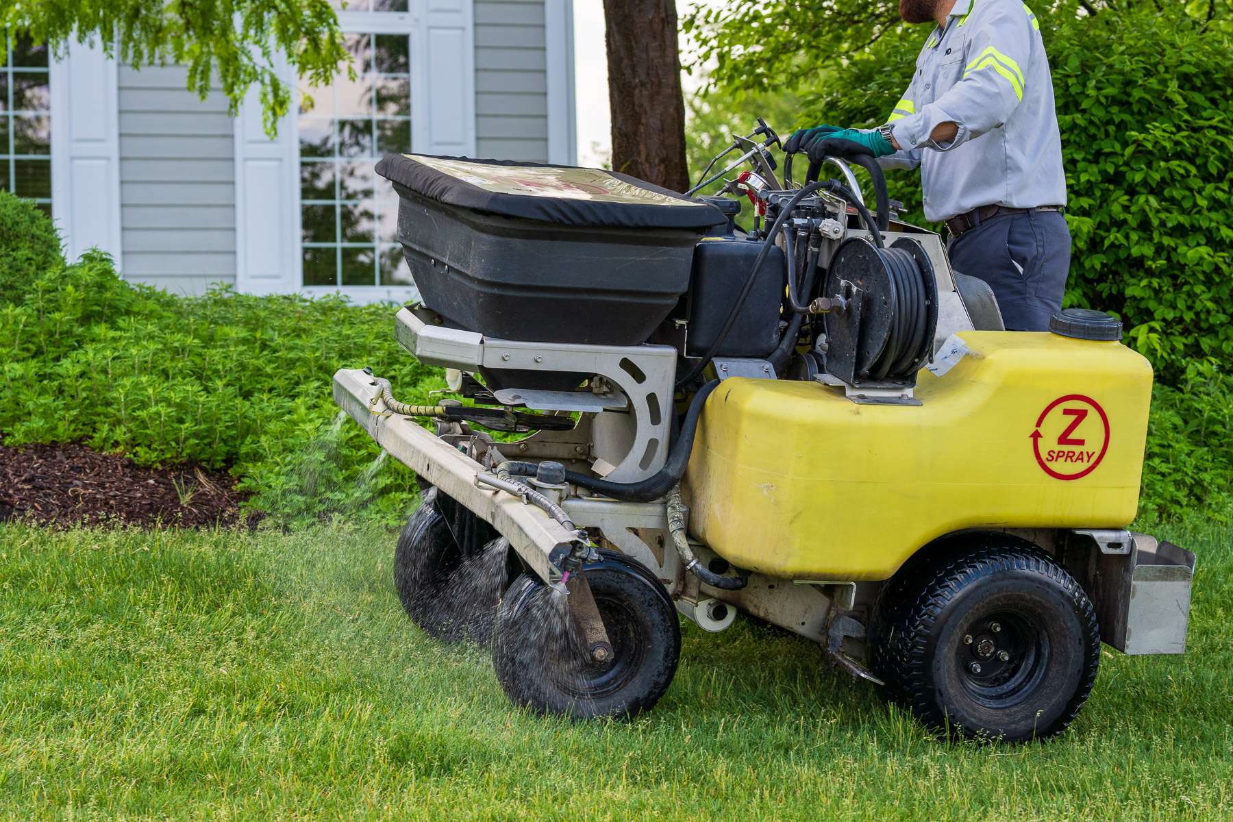 commercial lawn care technician spraying 17