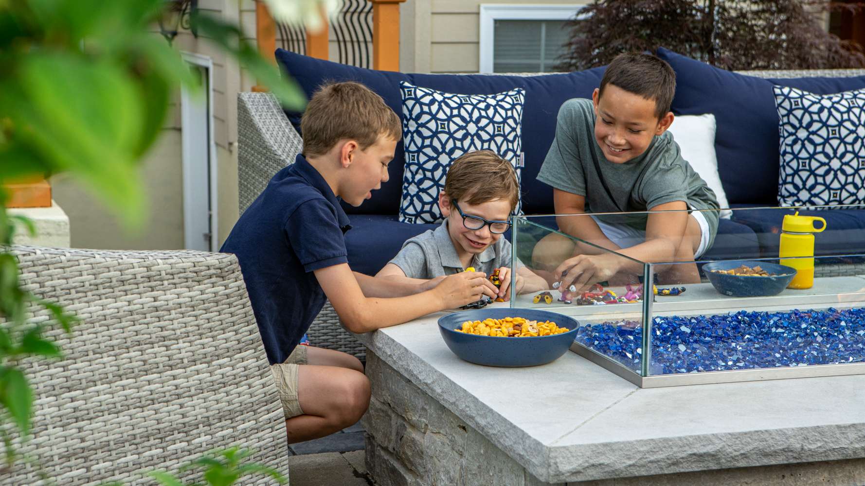 kids playing near an outdoor patio and firepit 