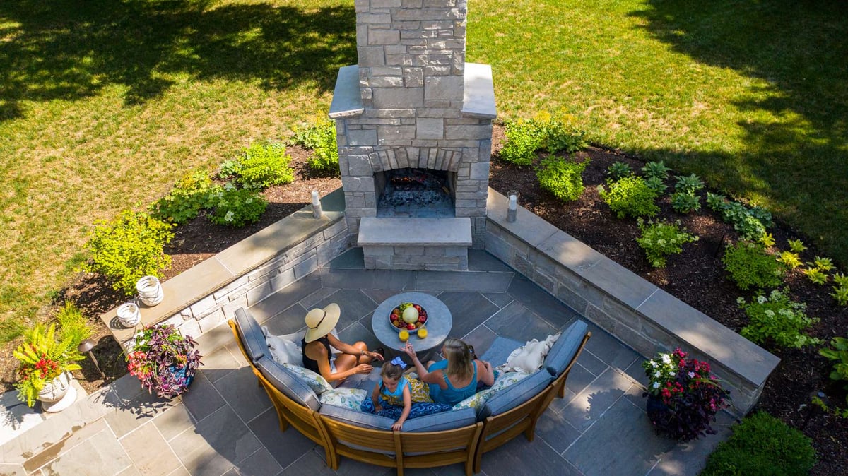 aerial view of family in front of outdoor fireplace