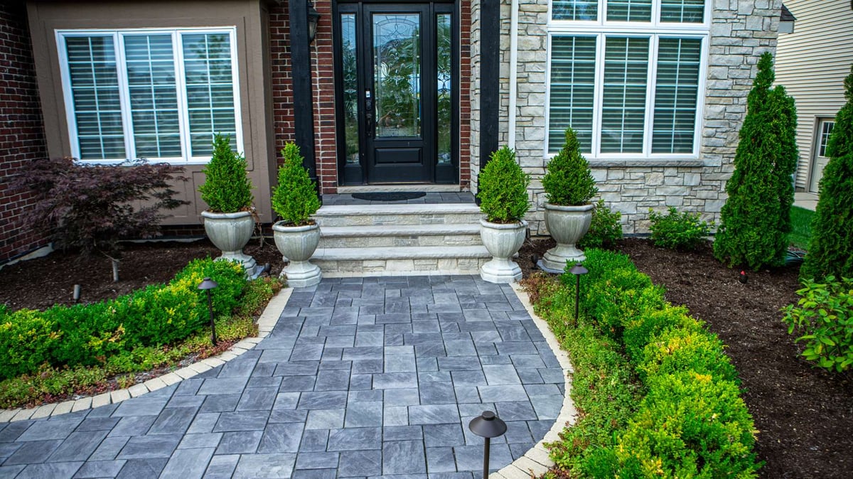 walkway to entrance of home with plantings and container gardens