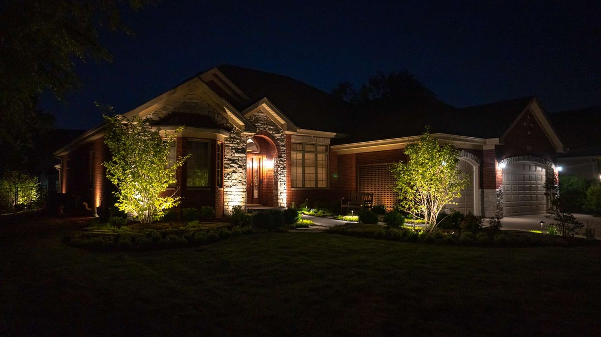 landscape lighting on trees at entrance of home