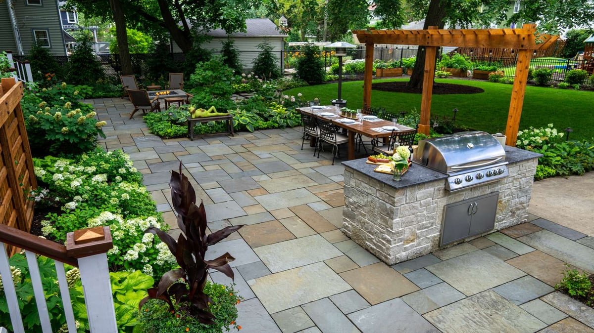 pergola on patio in large backyard with outdoor kitchen and seating area