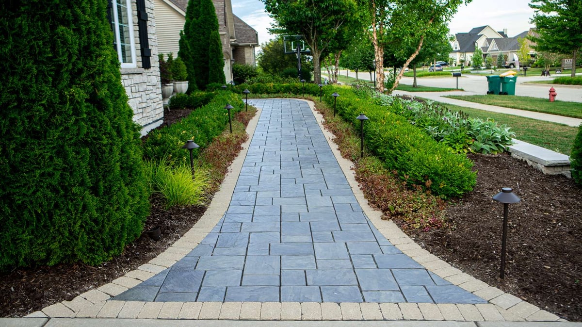 concrete paver walkway with landscape lighting and plantings