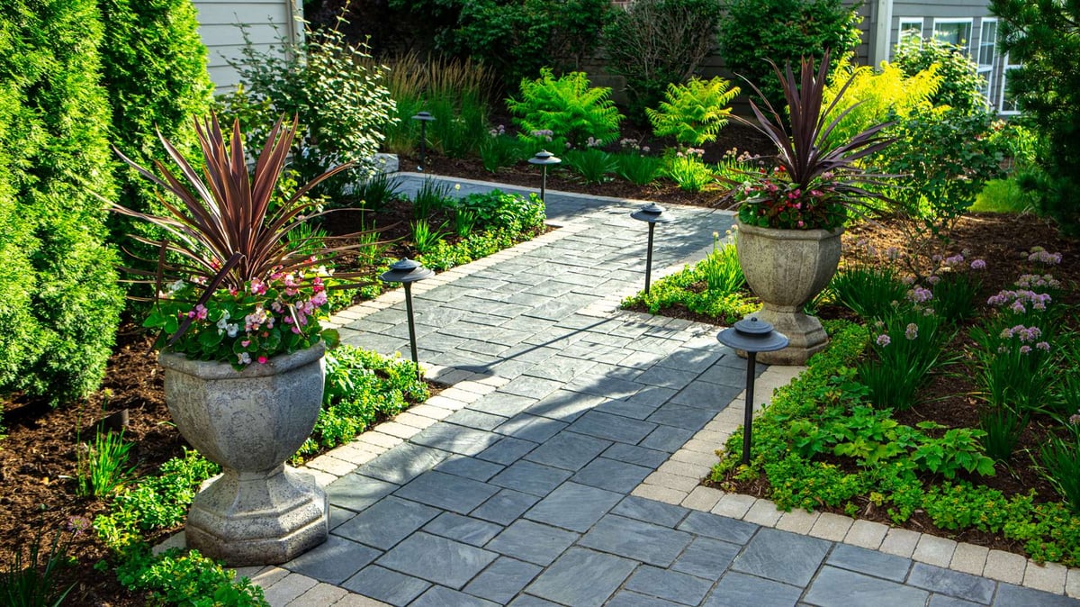 walkway with landscape lighting and container gardens