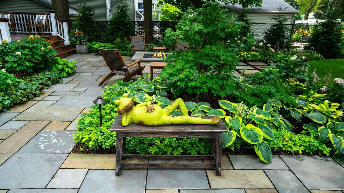 walkway with bench sculpture and plantings