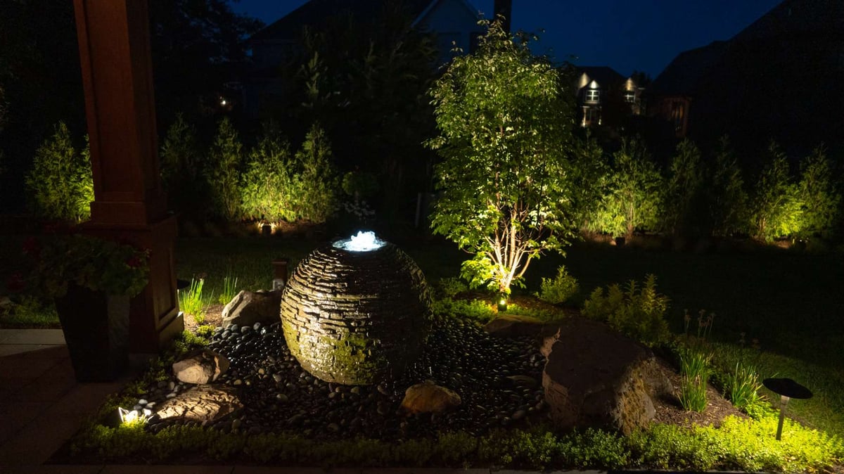 water feature and trees with landscape lighting