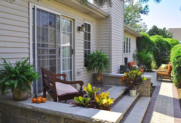 Container garden plants on steps to back entrance of home