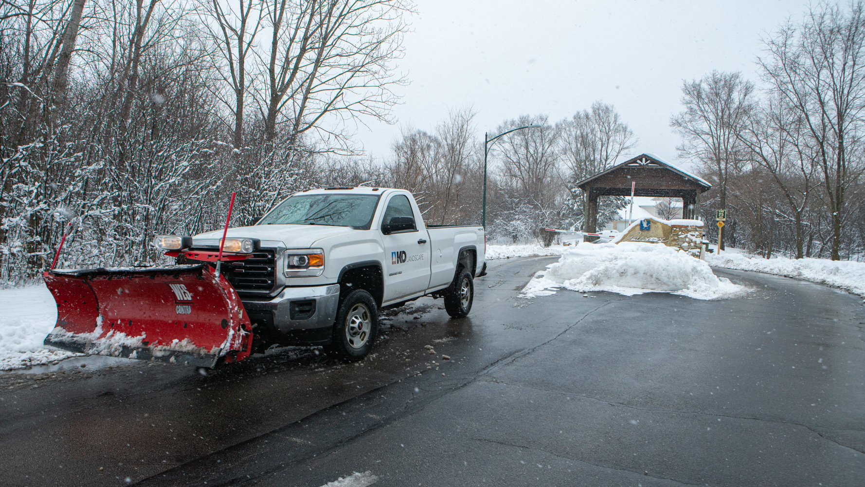 commercial snow removal truck plowing a neighborhood entrance