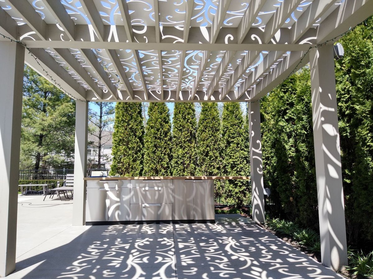 pergola with outdoor kitchen area surrounded by trees