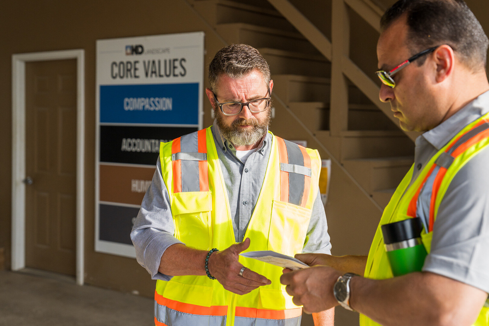 account manager and operations manager reviewing work at office in morning