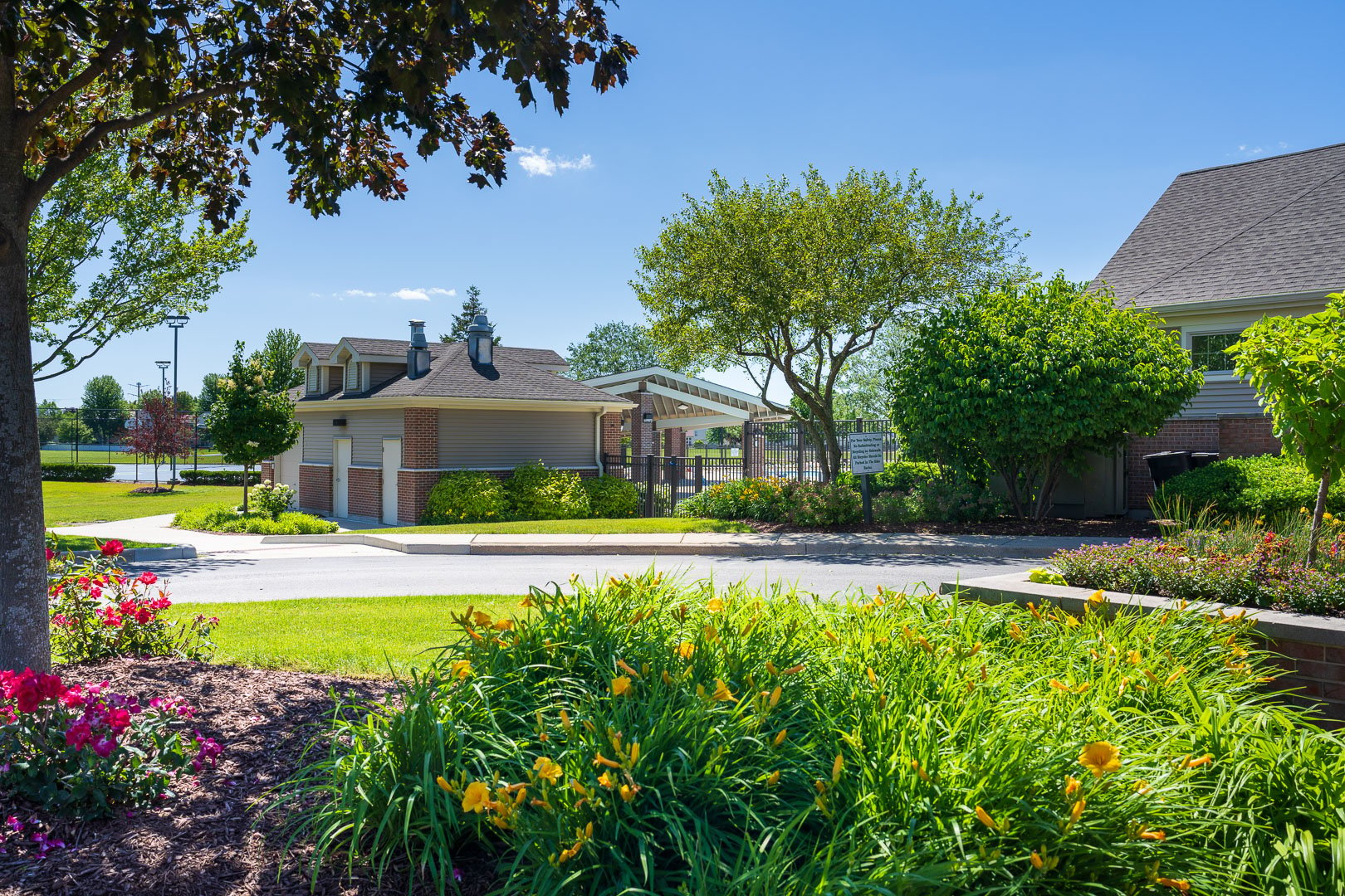 planting bed full of annuals and perennials in front of an HOA gatehouse