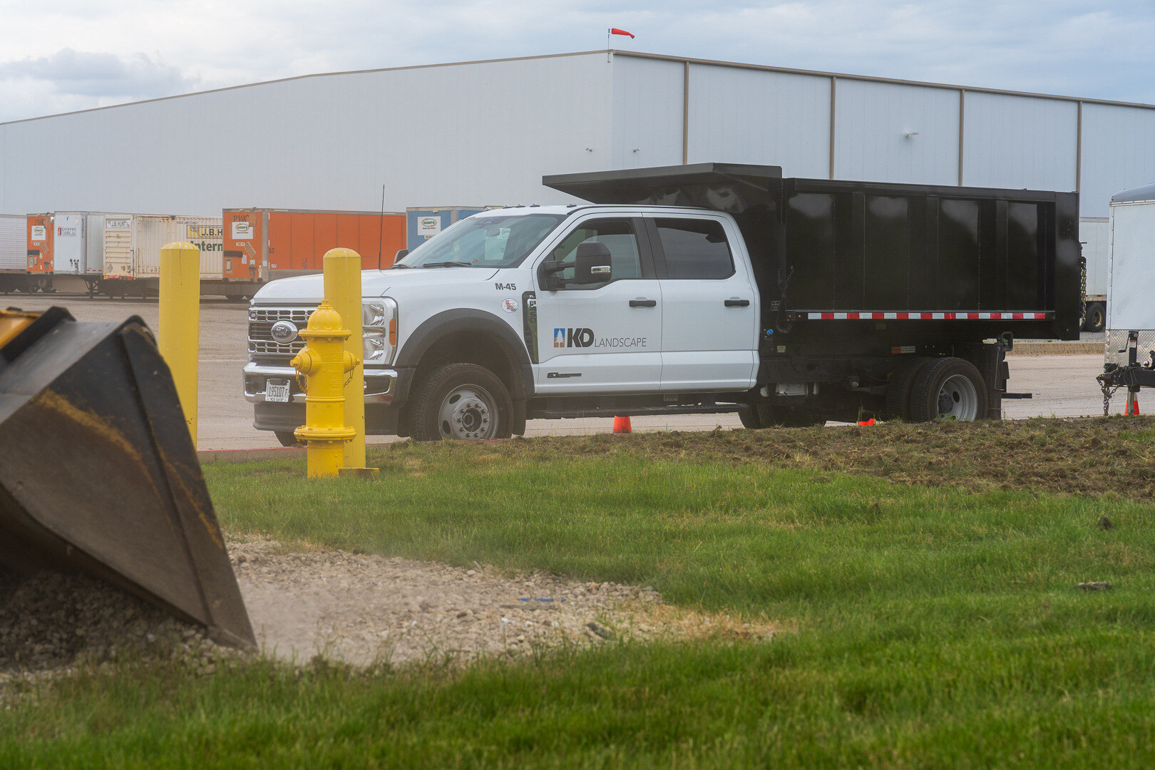 excavator and dump truck at a commercial landscape construction jobsite