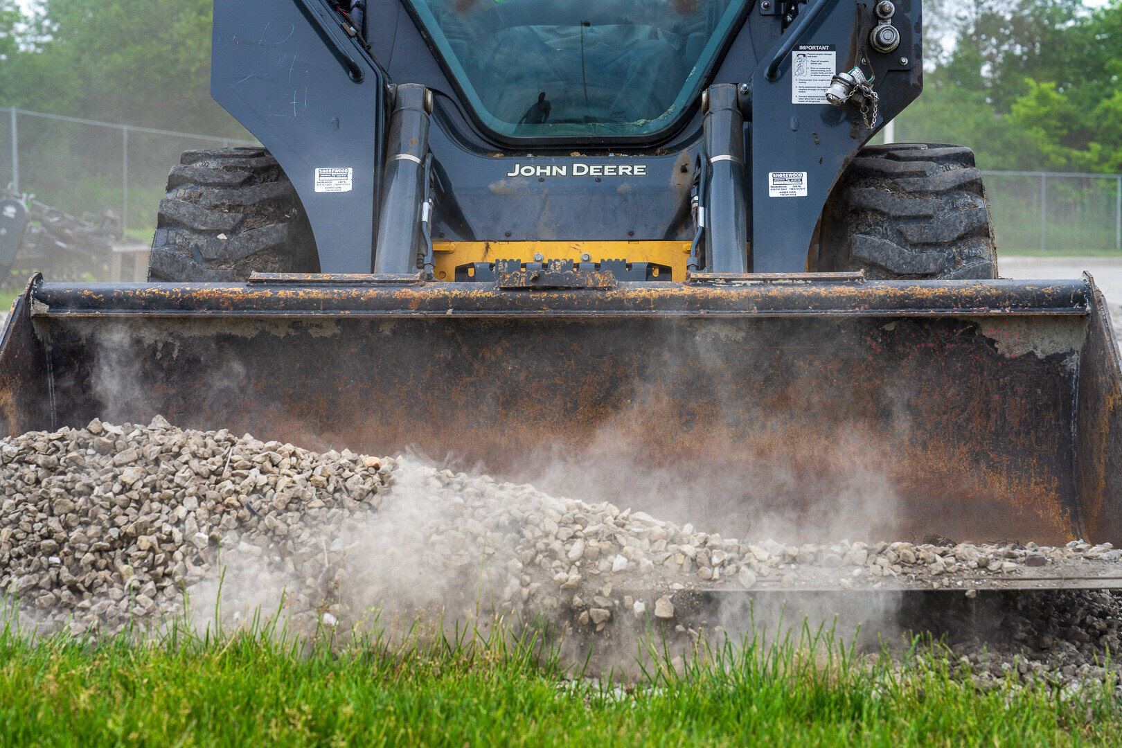 skid steer loading gravel on a commercial landscaping jobsite