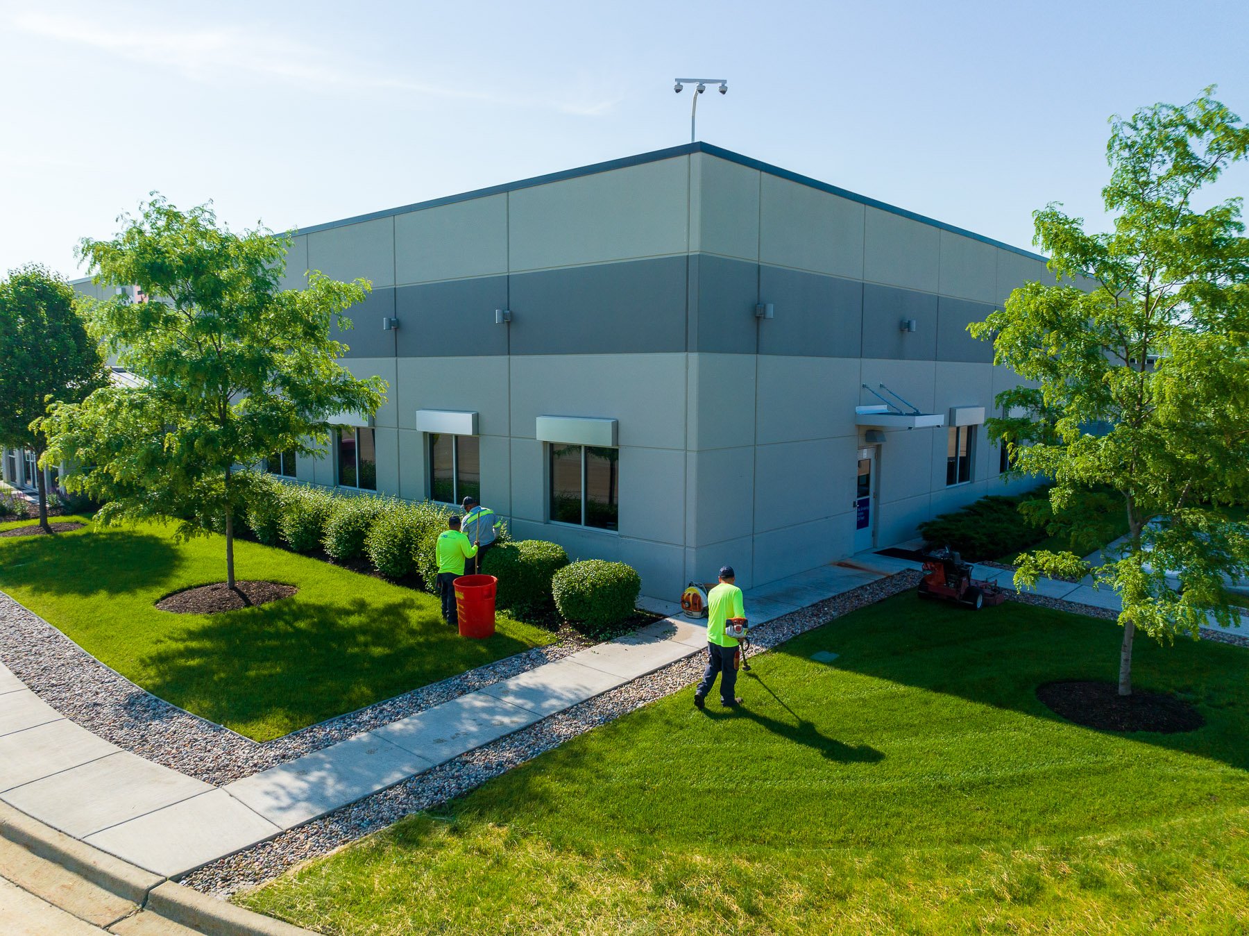 commercial maintenance technicians mowing warehouse