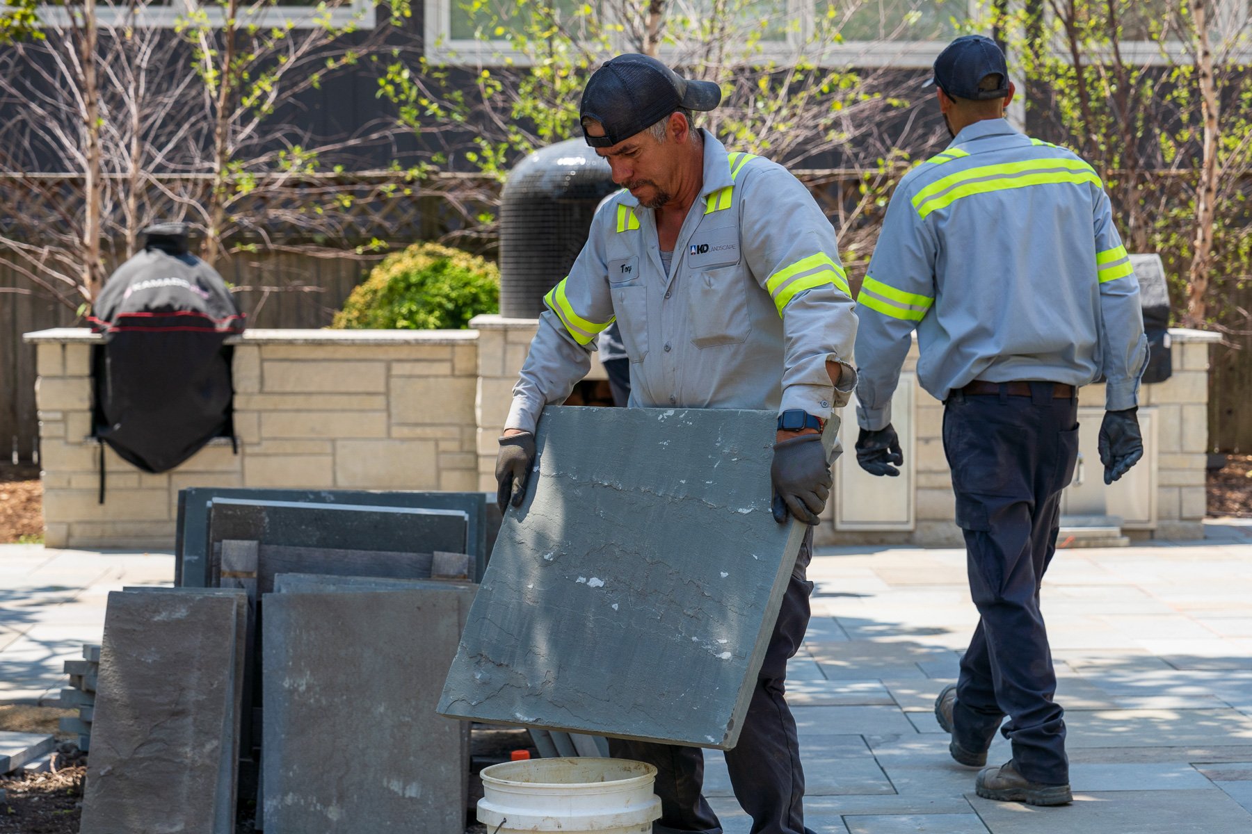 hardscape installation crew laying pavers in a courtyard