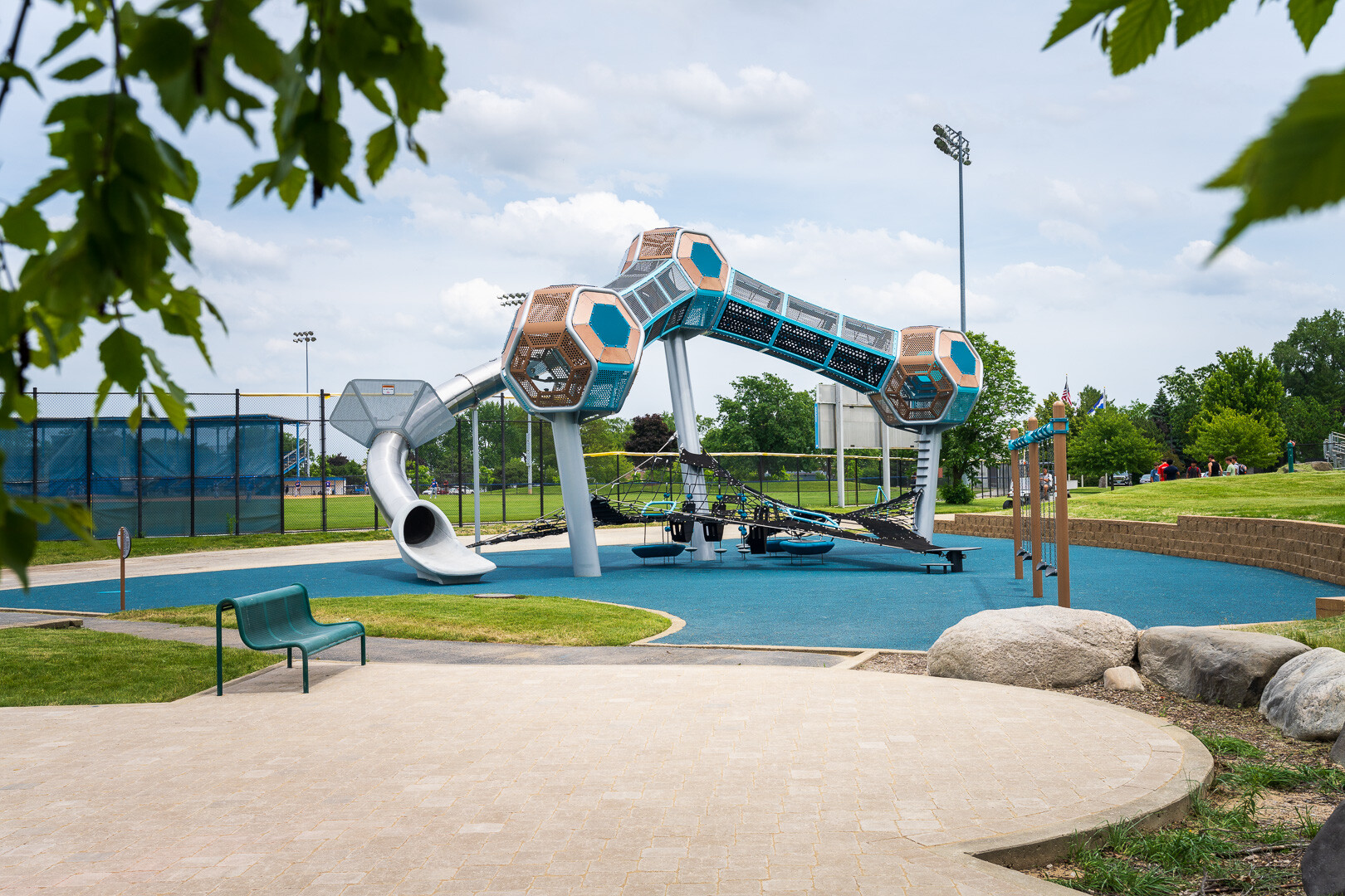 commercial playground with paver patio and border boulders