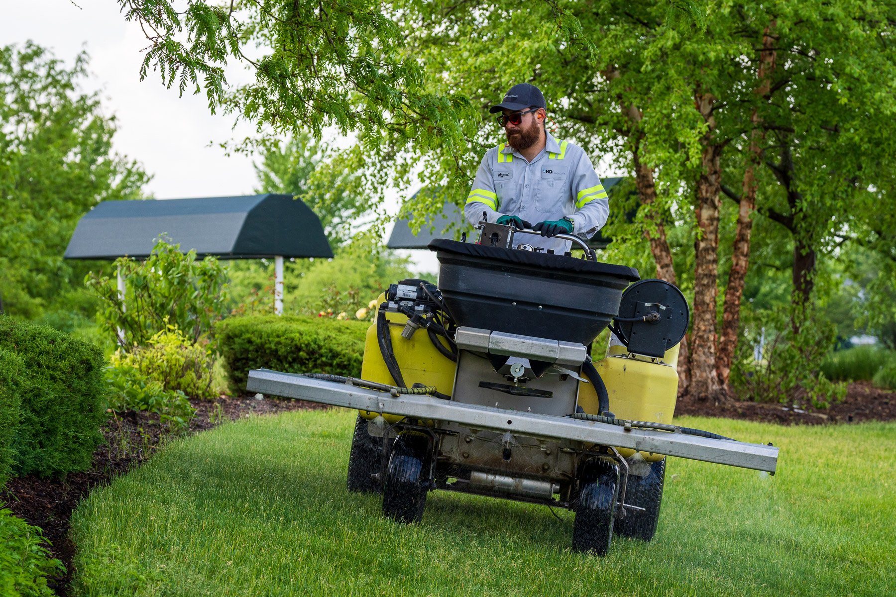 commercial lawn care technician spraying 15